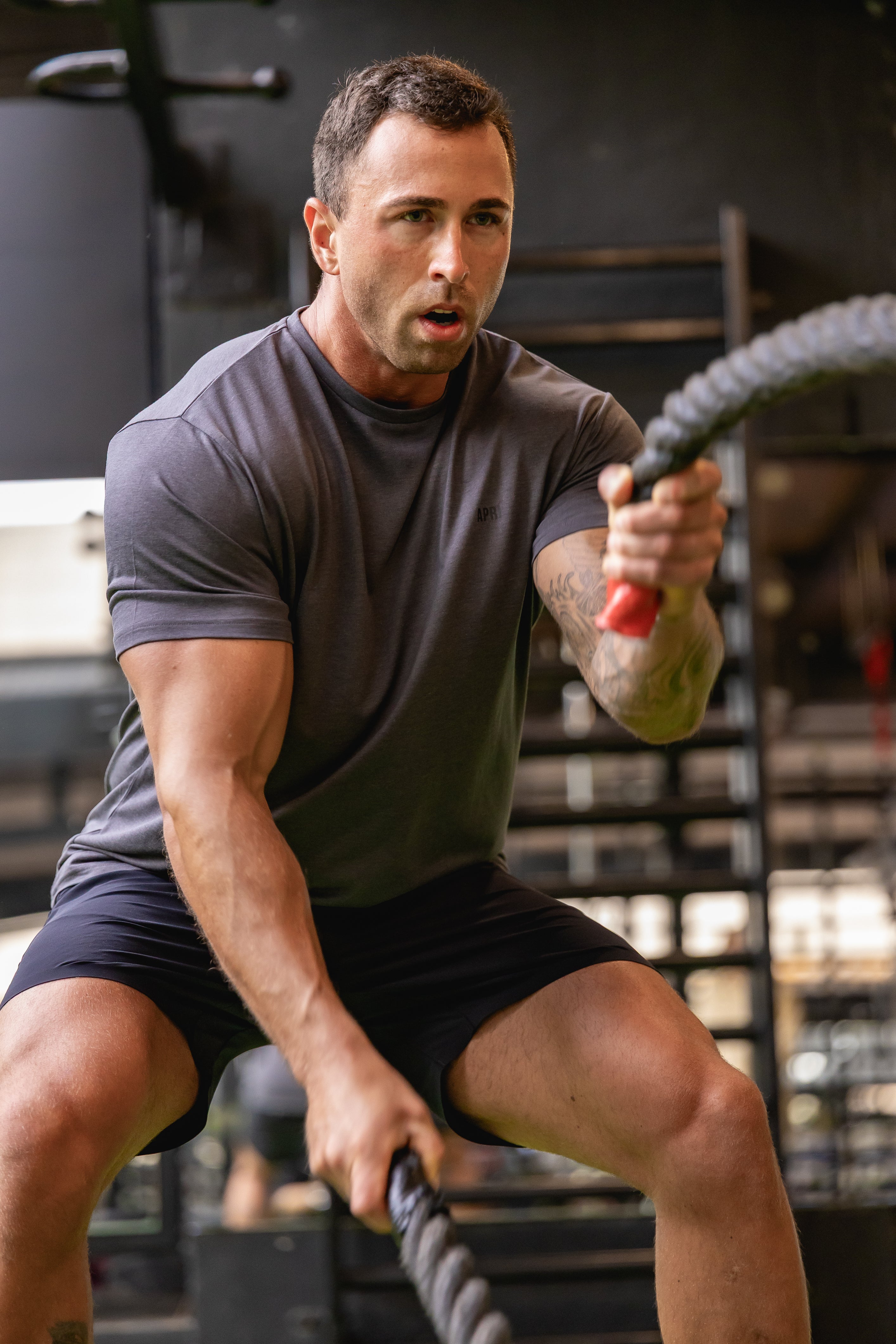 Man exercising with battle ropes in a gym setting. Asphalt Lyocell T-shirt